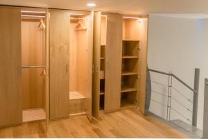 a walk in closet with wooden cabinets and shelves at Loft 717 in El Gallinero