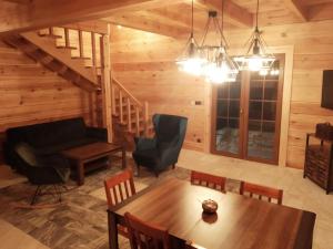 a living room with a table and chairs and a couch at Chata Sosenka in Sygontka