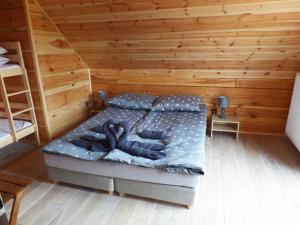 1 dormitorio con 1 cama en una habitación de madera en Chata Sosenka en Sygontka