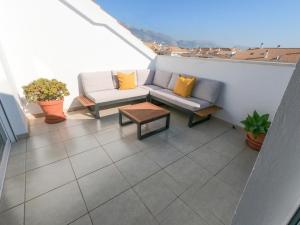 a balcony with a couch and a coffee table at ÁTICO ALTEA BLANCA in Altea