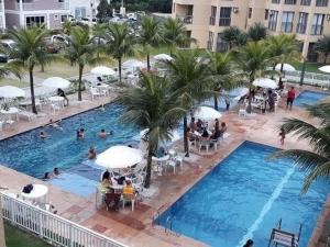 een uitzicht over een zwembad met mensen in een hotel bij Loft Aldeia dos Reis in Mangaratiba
