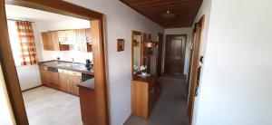 a kitchen with wooden cabinets and a door leading to a hallway at Ferienwohnung Wenzl in Schnaitsee