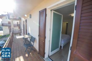 un balcone con porta che si apre su una camera da letto di Trentino Apartments - Casa ai Tolleri a Folgaria