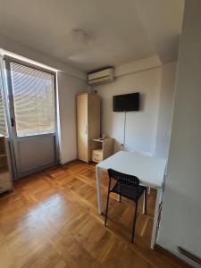 Cette petite chambre comprend une table blanche et une chaise. dans l'établissement Apartman Panorama 3 Glavna ulica, à Užice