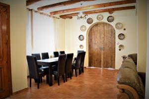 a dining room with a table and chairs and a wooden door at Cabana Soveja in Soveja