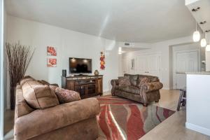 a living room with two couches and a flat screen tv at Downtown Condo Near Convention Center (Disability Access) in Salt Lake City