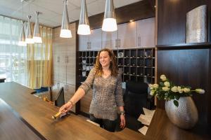 a woman standing at a table in a room at City Hotel Ansbach am KaDeWe in Berlin