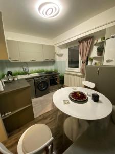 a kitchen with a white table and a table and chairs at Eden Luxury in Brăila