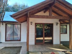 普孔Cabañas Noche Estrellada Pucón的白色的小房子,设有大木门