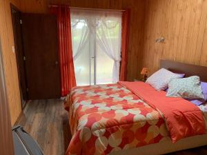a bedroom with a bed with a large window at Cabañas Noche Estrellada Pucón in Pucón