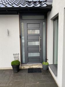 a front door of a house with two potted plants at Studio Apartment 7Heaven in Malmö