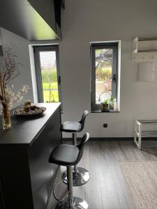 una cocina con 2 taburetes y 2 ventanas en Studio Apartment 7Heaven, en Malmö