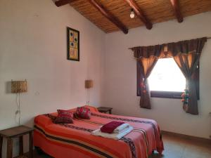 a bedroom with a bed and a window at La Posada de la Calandria in Purmamarca