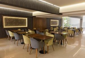 uma sala de jantar com mesas e cadeiras de madeira em Urbana Class Hotel em Mendoza