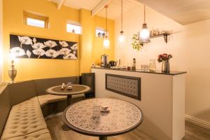comedor con 2 mesas y paredes amarillas en Hostería Hostal Malvinas en Ushuaia