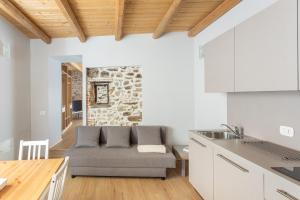 a living room with a couch in a kitchen at La Posteria by iCasamia it in Orino