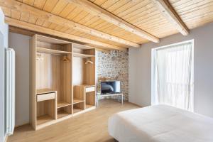 a bedroom with a bed and a desk and a television at La Posteria by iCasamia in Orino
