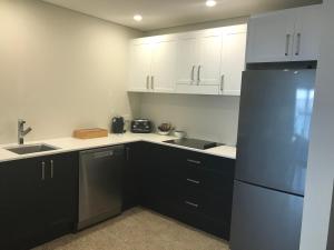 a kitchen with white cabinets and a black refrigerator at Inn Scone in Scone