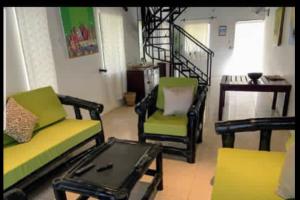 a living room with two chairs and a coffee table at Hibiscus House Gambia in Brufut