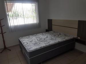 1 dormitorio con 1 cama en una habitación con ventana en Casa da Praia - Bombas II, en Bombinhas