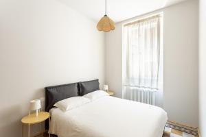 a bedroom with a white bed and a window at La Posteria by iCasamia in Orino