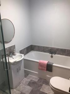 a bathroom with a tub and a sink and a toilet at Littles Cottage, heart of the Mournes in Annalong +31 photos