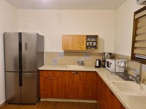 a kitchen with a stainless steel refrigerator and a sink at נוף הרים Mountain View in Neve Daniel