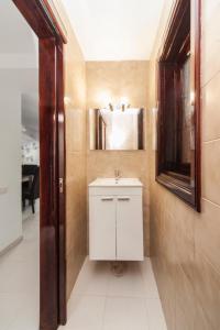 a bathroom with a white sink and a mirror at Luxury House Grumete in Playa Honda