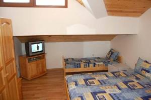 a room with two beds and a television in it at Guest Rooms Toni & Miro in Tryavna