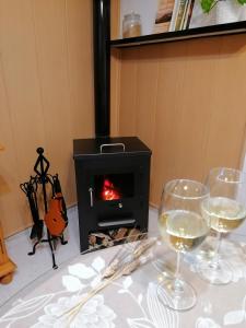 two wine glasses sitting on a table with a stove at Los Trigos, Casa Rural in Montejaque