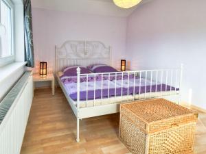 GustowにあるModern Holiday Home in Gustow near Baltic Seaのベッドルーム(紫のシーツを使用した白いベッド1台付)