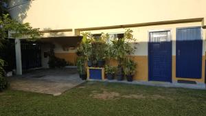 una casa con una puerta azul y un montón de plantas en Apartamento perto de praia Dos Anjos, en Arraial do Cabo