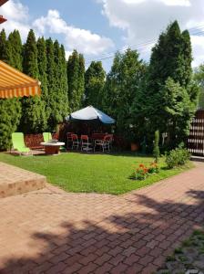 a patio with a table and chairs and an umbrella at Szetti Nyaraló in Balatonszárszó