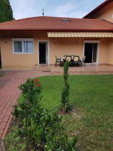 a house with a table and chairs in a yard at Szetti Nyaraló in Balatonszárszó