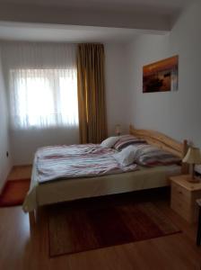 a bedroom with a large bed with a window at Szetti Nyaraló in Balatonszárszó