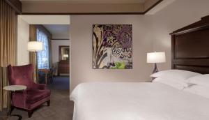 a hotel room with a bed and a chair at The Ashton Hotel in Fort Worth +12 photos