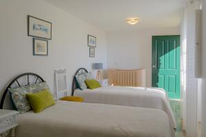 1 Schlafzimmer mit 2 Betten und einer grünen Tür in der Unterkunft Recanto das Florenças (1) in Arco da Calheta
