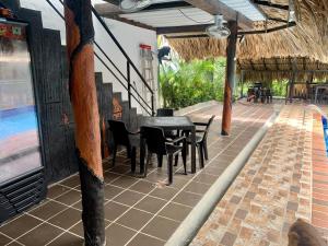 a patio with a table and chairs and a pool at Cabaña hotel conde in Doradal
