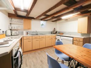 uma cozinha com armários de madeira e uma mesa de madeira em Hook's House em Scarborough