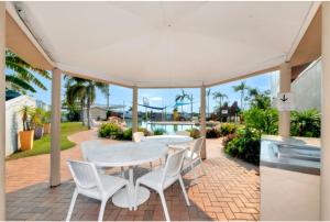 patio ze stołem i krzesłami na ceglanym patio w obiekcie Discovery Parks - Townsville w mieście Townsville