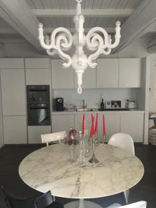 a white kitchen with a table and a chandelier at Luxury My home in Tolentino