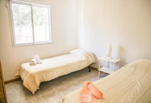 een kamer met twee bedden en een raam bij Casa en Claromecó La Alegria in Balneario Claromecó