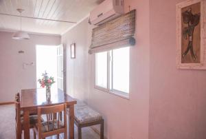 een eetkamer met een tafel en stoelen en een raam bij Casa en Claromecó La Alegria in Balneario Claromecó