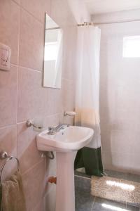 een badkamer met een wastafel en een spiegel en een douche bij Casa en Claromecó La Alegria in Balneario Claromecó