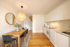 a kitchen and dining room with a table and a mirror at FLH Aliados Loft in Porto