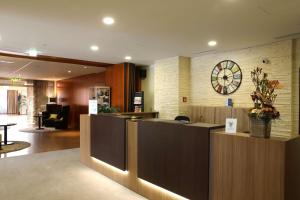 a lobby with a reception desk and a clock on the wall at Best Western Hotel Rosenau in Bad Nauheim
