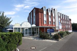 un edificio rojo con un cartel delante en Best Western Hotel Rosenau en Bad Nauheim