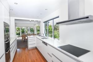 a kitchen with white cabinets and a large window at Lismore Views in Wanaka