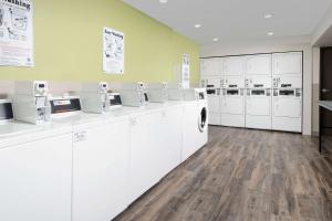 eine große Waschküche mit weißen Waschmaschinen und Trocknern in der Unterkunft Woodspring Suites Orlando International Drive in Orlando