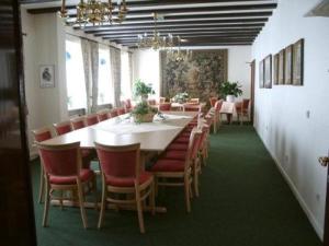 ein Esszimmer mit einem langen Tisch und Stühlen in der Unterkunft Hotel Krohwinkel in Hittfeld